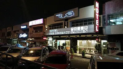 a city street with cars parked in front of a theater at The Regency Garden Hotel in Ipoh