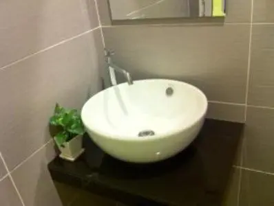 a white sink on a black counter in a bathroom at The Regency Garden Hotel in Ipoh