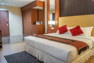 a hotel room with a large bed with red pillows at Hotel Pen Mutiara in Kampong Batu Maung