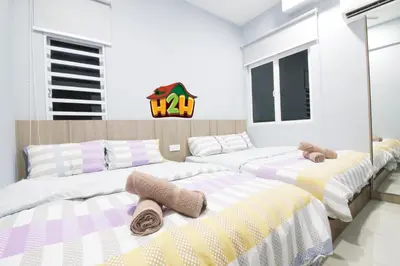 a bedroom with three beds with towels on them at H2H - TT Court Majestic Ipoh in Ipoh