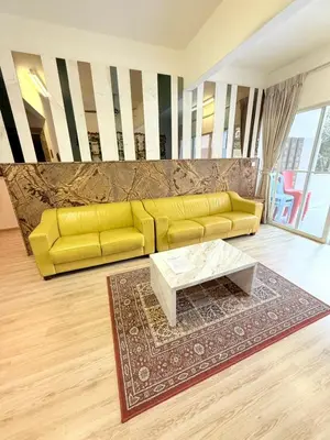 a living room with a yellow couch and a coffee table at The Haven Retreat B7-2-1 ( Silverpark) in Bukit Fraser