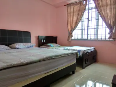 two beds in a bedroom with two windows at Tenang & Tranquil Homestay - B605 Cameron Highlands in Brinchang