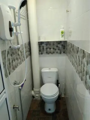 a small bathroom with a toilet and a shower at Fastbook Majestic Home 10pax in Ayer Itam