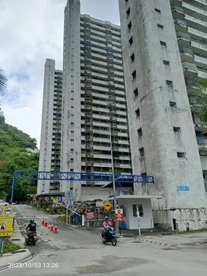 two tall buildings with people riding motorcycles in front of them at Fastbook Majestic Home 10pax in Ayer Itam
