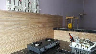 a stove in a kitchen with a counter top at Cottage Muslim Homestay ByWawaSha in Tanjung Malim