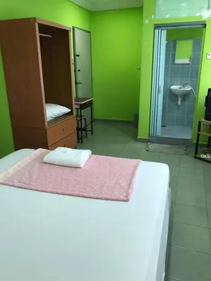 a bedroom with a bed and a bathroom with a sink at Hotel Cahaya in Tanjung Malim