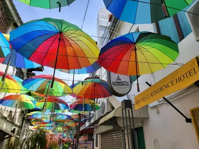 a bunch of colorful umbrellas hanging from a building at The Boutique Residence Hotel in George Town