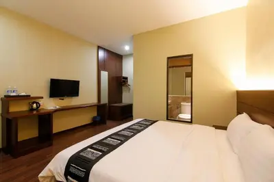 a hotel room with a bed and a television at Art Cottage Hotel in Ipoh