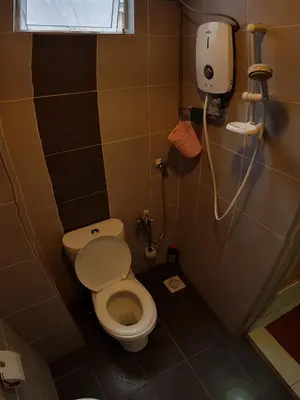 a small bathroom with a toilet and a window at Baoyousongsong in Kampar