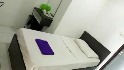 a white couch with a purple napkin on it at Hotel Checkedinn in Ipoh