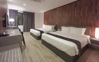 a hotel room with two beds and a desk at Frame Hotel in George Town