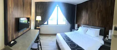 a hotel room with a bed and a television at Frame Hotel in George Town