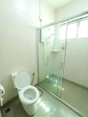 a bathroom with a toilet and a glass shower at TROPICAL LIVINGS MERU IPOH HOMESTAY by Grab A Stay in Ipoh