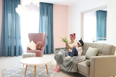 a woman and a child sitting on a couch in a living room at Octagon Ipoh by Plush in Ipoh