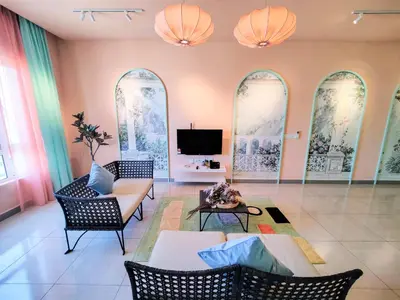 a living room with a couch and chairs and a tv at Octagon Ipoh by Plush in Ipoh