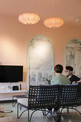 two people sitting in a room with a tv at Octagon Ipoh by Plush in Ipoh