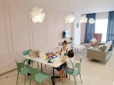 two children sitting at a table in a living room at Octagon Ipoh by Plush in Ipoh