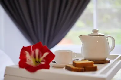 a table with a tea pot and a red flower at Ahn-Yi Residence in Brinchang