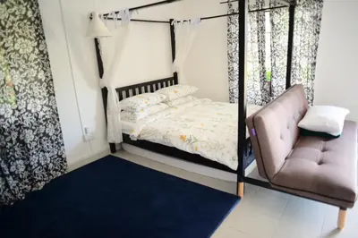 a bedroom with a bed and a chair at Tiny Boutique Habitat in Tanah Rata