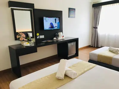 a hotel room with two beds and a flat screen tv at Hotel Seri Malaysia Sungai Petani in Sungai Petani