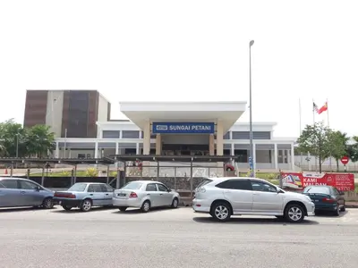 a parking lot with cars parked in front of a building at Hotel Seri Malaysia Sungai Petani in Sungai Petani