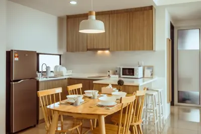 a kitchen and dining room with a wooden table and chairs at Muji X Tiffany - City and Hill View 3BR at 218 Tropicana NEAR Komtar Food Heaven with Netflix & TV Box in George Town