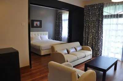 a living room with a white couch and a bed at Strawberry Park Resort in Cameron Highlands