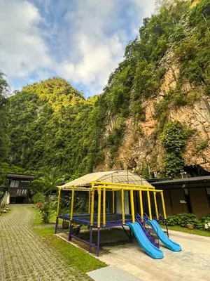 a playground with a slide in front of a mountain at Xscape Tambun in Ipoh