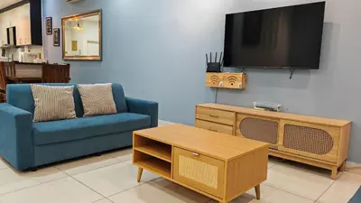 a living room with a blue couch and a tv at Ocean 25 Shamrock Beach Big Group 6 Bedroom 5 Bathroom with Pool in Tanjung Bungah