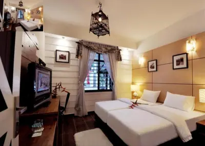 a bedroom with two beds and a tv and a window at Kinta Bali Villa in Ipoh