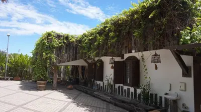 a white building with a fence with vines at Kinta Bali Villa in Ipoh