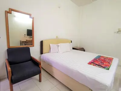 a bedroom with a bed and a mirror and a chair at Star Lodge in George Town