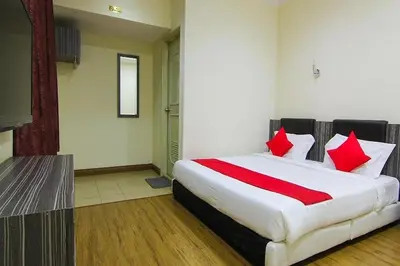 a bedroom with a large bed with red pillows at T P Hotel in Sitiawan