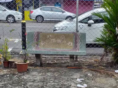 a sign sitting in front of a fence at Hotel Peking in Taiping