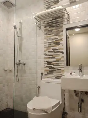 a bathroom with a toilet and a sink and a shower at Ritz Suites in Lumut