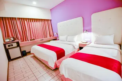 a hotel room with two beds and purple walls at Ritz Suites in Lumut