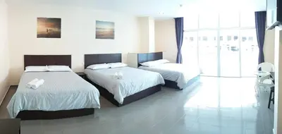 a bedroom with two beds and a large window at Hotel Pangkor SJ in Pangkor