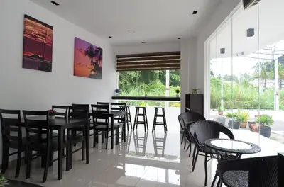 a dining room with black tables and chairs at Hotel Pangkor SJ in Pangkor