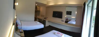 a hotel room with two beds and a television at SERDANG LAKE VIEW RESORT in Sungai Kechil
