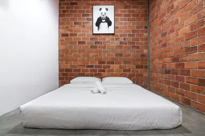 a bed in a room with a brick wall at UrbanStay Industrial in Ipoh