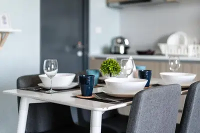 a white table with glasses and plates on it at Tropicana 218 Macalister by Simply Penang in George Town