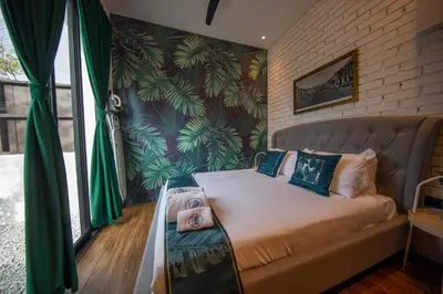 a bedroom with a bed with a couch in it at Carnarvon Suites in George Town