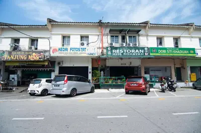 a parking lot with cars parked in front of a building at Hotel O Hajah Rohayah in Tanjung Malim