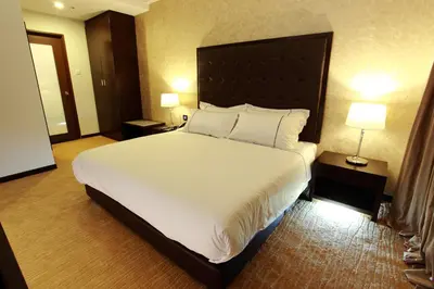 a bedroom with a large bed with white sheets and pillows at Symphony Suites Hotel in Ipoh