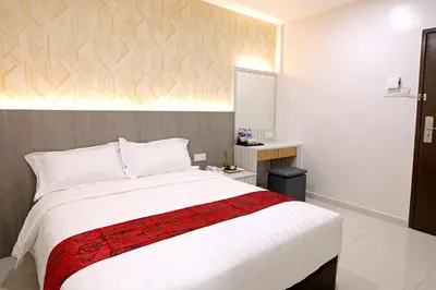 a bedroom with a large bed with a red blanket at B&L HOTEl in Sungkai