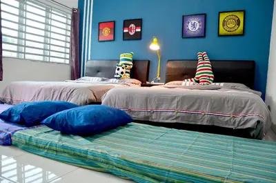 a room with two beds with pillows and a couch at The Woodz Homestay - 2 Storey Landed House in Cameron Highlands
