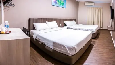 a hotel room with two beds and a television at K West Hotel in Sitiawan