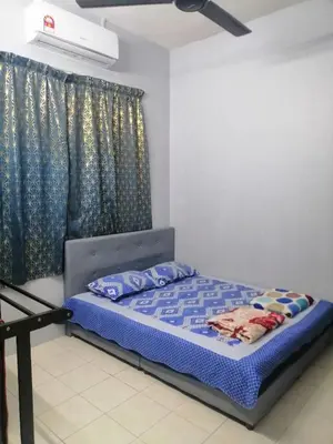 a bedroom with a bed with blue sheets and a window at Syaqisya Homestay in Seri Manjung