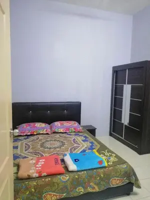 a bedroom with a bed with a black headboard at Syaqisya Homestay in Seri Manjung