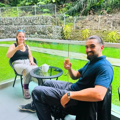 a man and a woman sitting at a table with drinks at A3A Oastel CoLiving in Tanah Rata